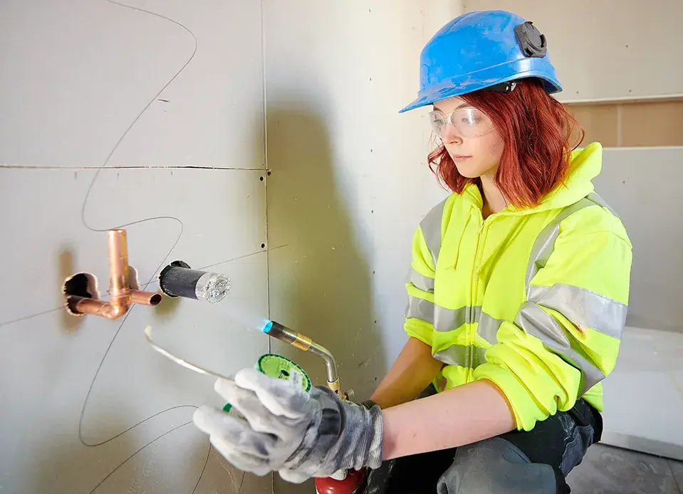 Commercial plumber holding a pipe